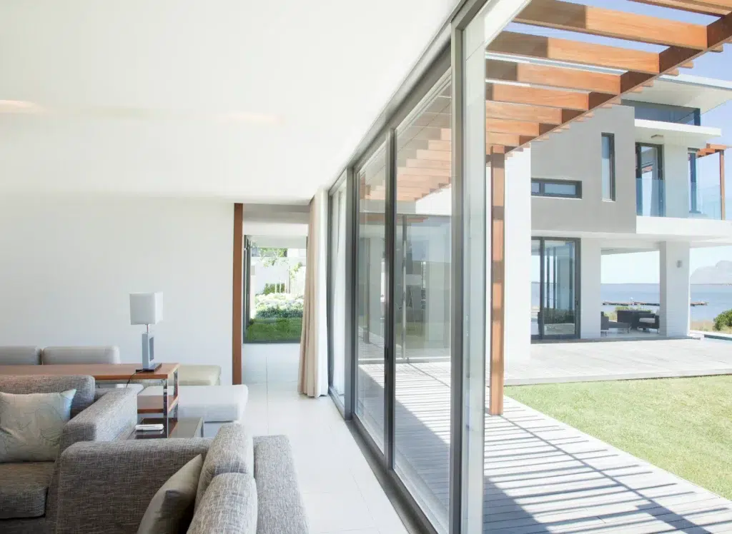 Large-scale Viewlux aluminum sliding doors in a modern living room connecting to an outdoor patio with a pergola.